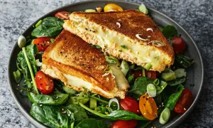 En gyllene, smältande tuna melt serveras på en bädd av färsk spenat, körsbärstomater och gurka.