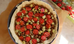 En tacopaj redo för ugnen, fylld med köttfärs, tomater och paprika. Ett perfekt tacopaj recept för hela familjen.