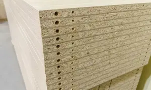 En stapel spånskivor med förborrade hål, redo att måla för ett nytt projekt.