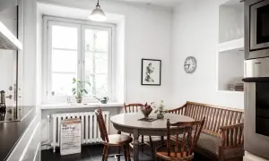 Mysig köksvrå med runt matbord, träbänk och stolar. Perfekt för runt matbord inspiration.