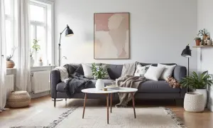En grå soffa med många kuddar och plädar, ett runt soffbord och en matta skapar en mysig bohemisk inredning.
