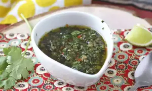 En skål med färsk chimichurri, perfekt för ditt nästa grillrecept. Serveras med lime och koriander.