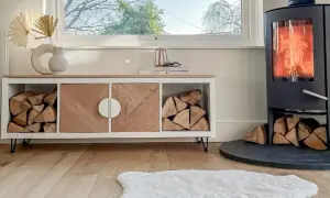 Ett smart kallax hack med vedförvaring och snygga trädetaljer. En mysig braskamin värmer rummet.