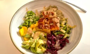 En färgglad bowl med lax, quinoa, edamame, mango, avokado och rödbetor. Perfekt nyttig snabbmat för en hälsosam lunch eller middag.