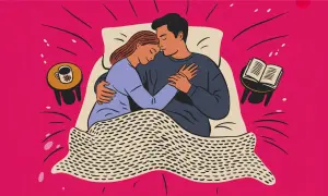 Ett par kramas i sängen. En bok och en kaffekopp står på sängbordet. Kärlek och intimitet, även under mens.