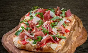 En avsmaklig pinsa med prosciutto, ruccola och parmesan. Ett perfekt pinsa recept för en härlig måltid.