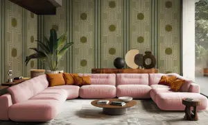 En rosa soffa och en stor grön växt i ett rum med exotisk inredning och en mönstrad tapet.