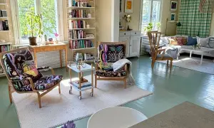 Ljust och luftigt vardagsrum med två färgstarka fåtöljer, bokhyllor och en soffgrupp. En känsla av harmoni och lugn som passar bra för feng shui vardagsrum.