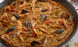 En stor paella fylld med räkor, musslor och ris. Ett perfekt paella recept för en festmåltid.