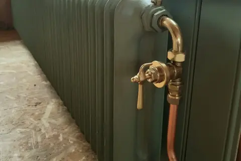 Ett grönt element med mässingsdetaljer, redo att bygga in i hallen för värme och stil.