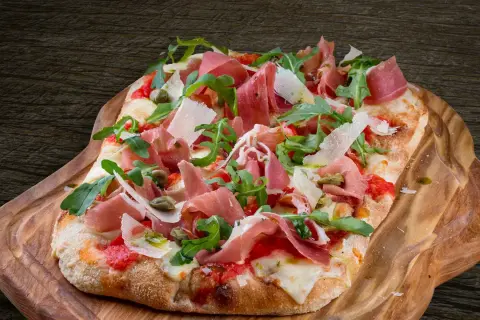 En avsmaklig pinsa med prosciutto, ruccola och parmesan. Ett perfekt pinsa recept för en härlig måltid.