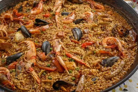 En stor paella fylld med räkor, musslor och ris. Ett perfekt paella recept för en festmåltid.
