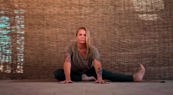 Kvinna i yinyoga-position med armarna utsträckta. Kan uppleva biverkningar som djup avslappning.