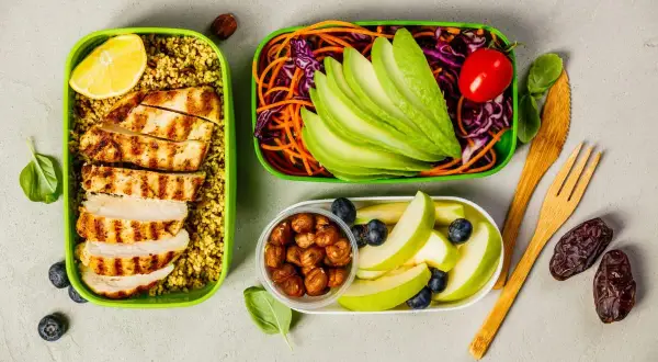 En hälsosam och **lågkalori frukost** med grillad kyckling, couscous, avokado, grönsaker, äpple och nötter. Perfekt för en energifylld start på dagen.