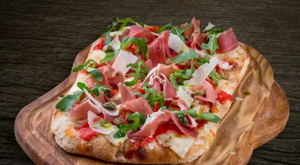 En avsmaklig pinsa med prosciutto, ruccola och parmesan. Ett perfekt pinsa recept för en härlig måltid.