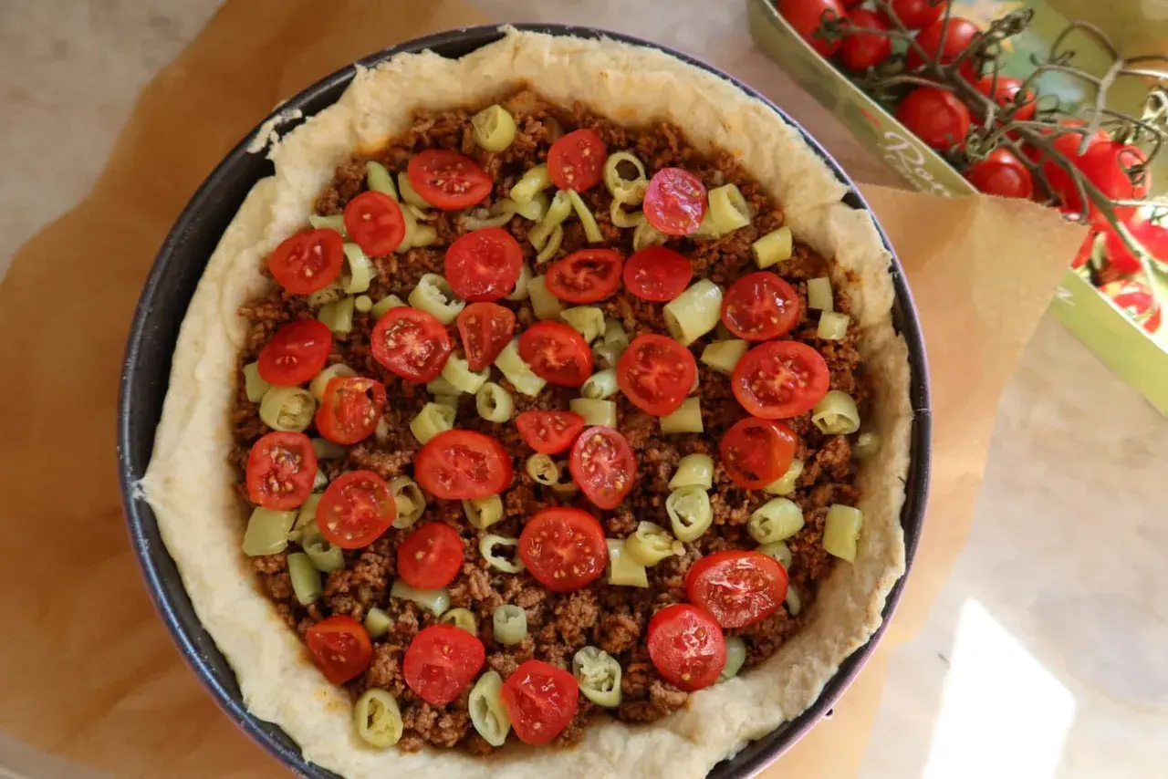 En tacopaj redo för ugnen, fylld med köttfärs, tomater och paprika. Ett perfekt tacopaj recept för hela familjen.