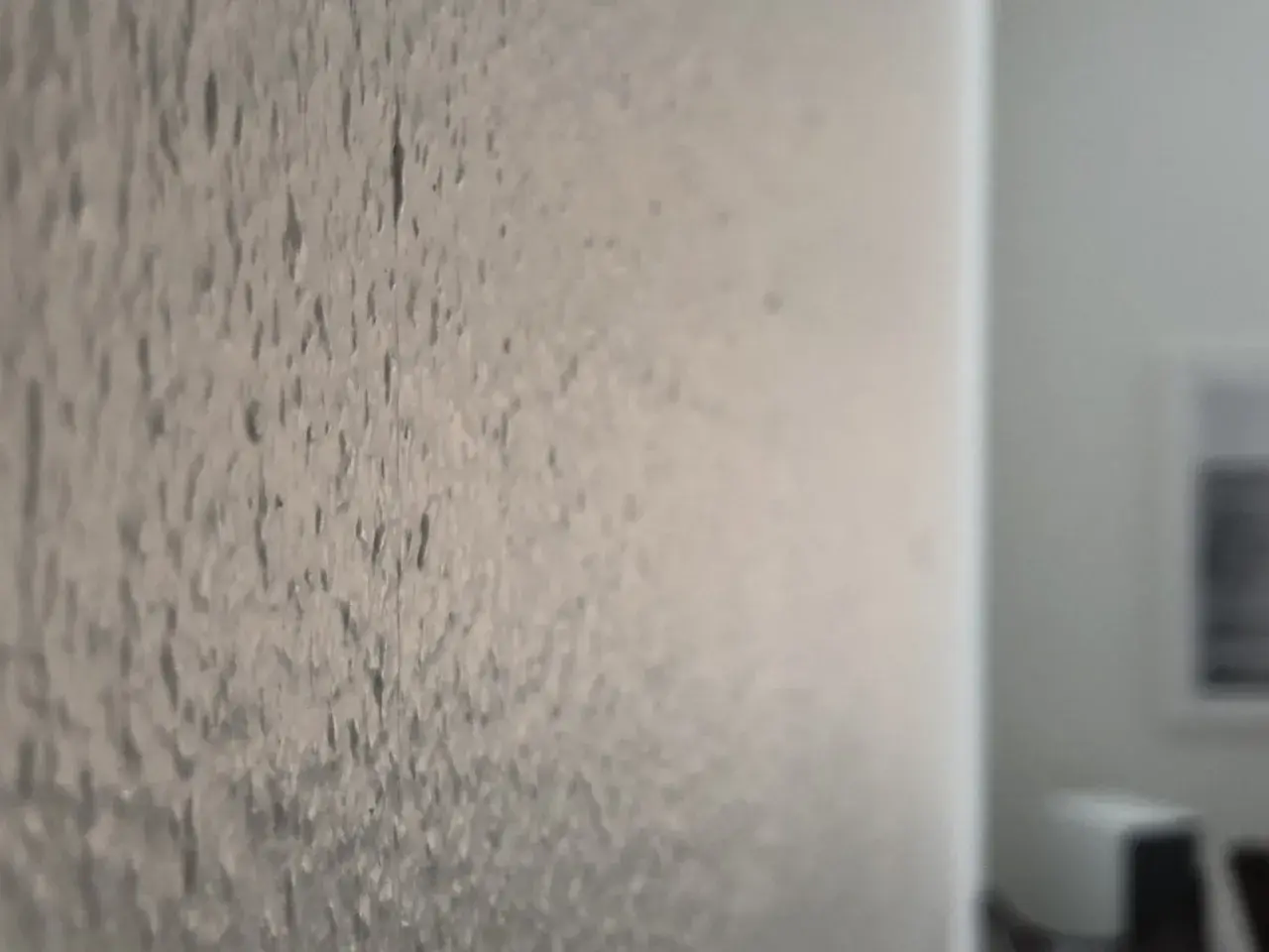 Närbild på en vägg där man kan se hur det ser ut att måla på strukturtapet. Texturen är tydlig.