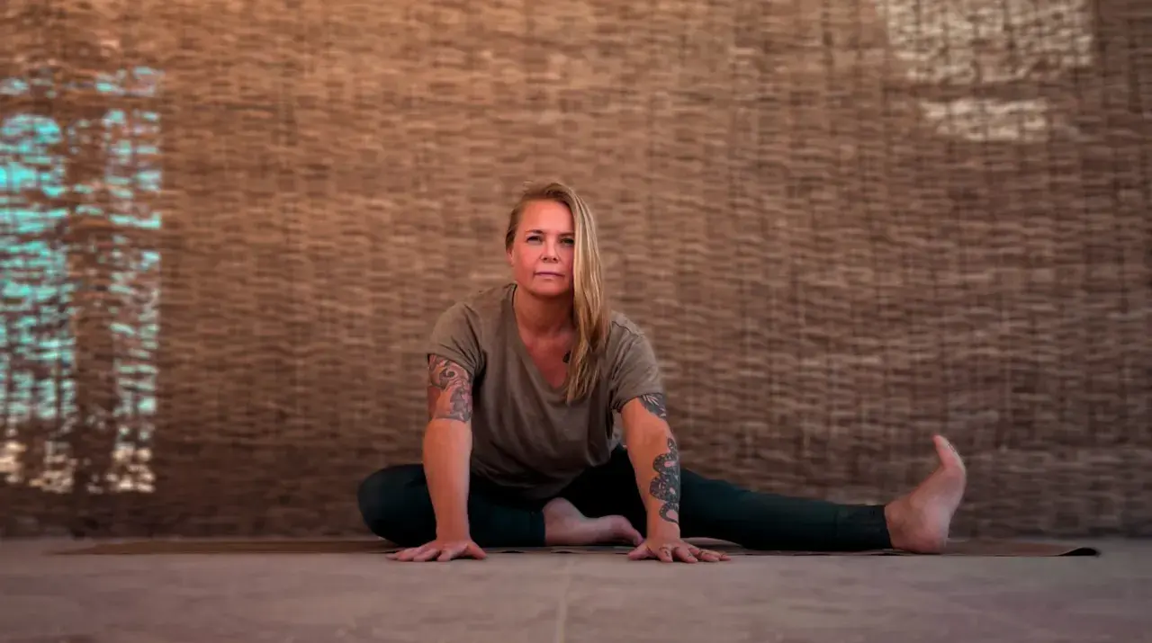 Kvinna i yinyoga-position med armarna utsträckta. Kan uppleva biverkningar som djup avslappning.