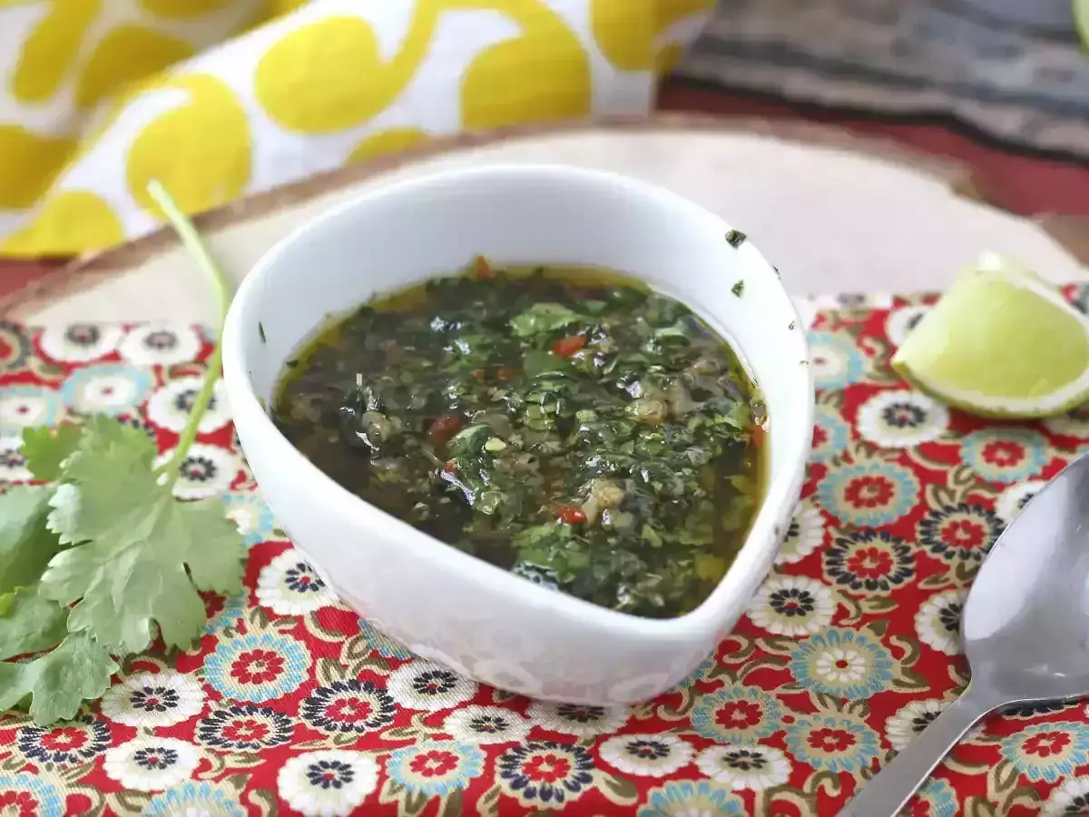 En skål med färsk chimichurri, perfekt för ditt nästa grillrecept. Serveras med lime och koriander.