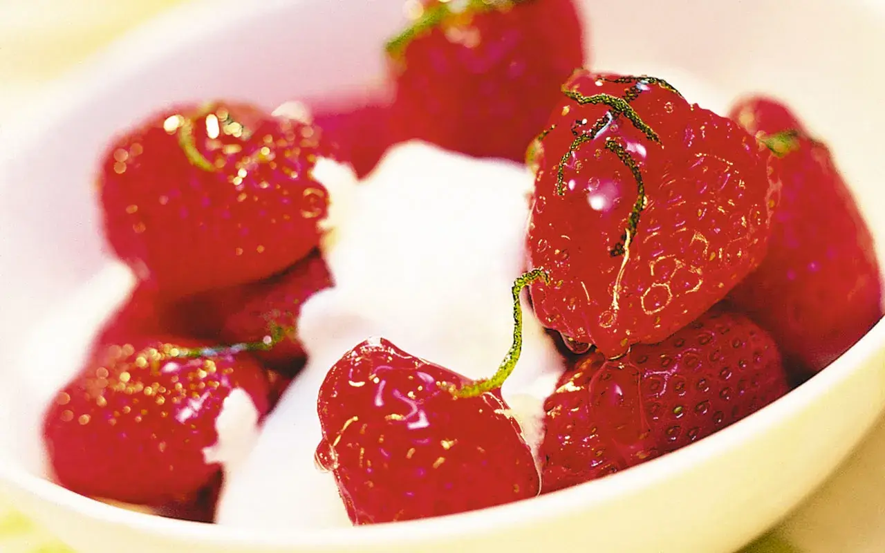 En skål med saftiga, limemarinerade jordgubbar och fluffig grädde. En härlig sommardessert.