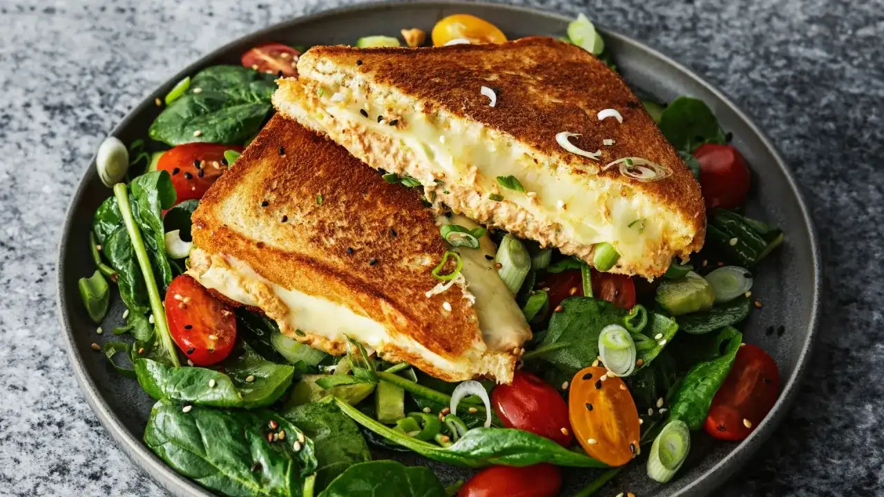 En gyllene, smältande tuna melt serveras på en bädd av färsk spenat, körsbärstomater och gurka.