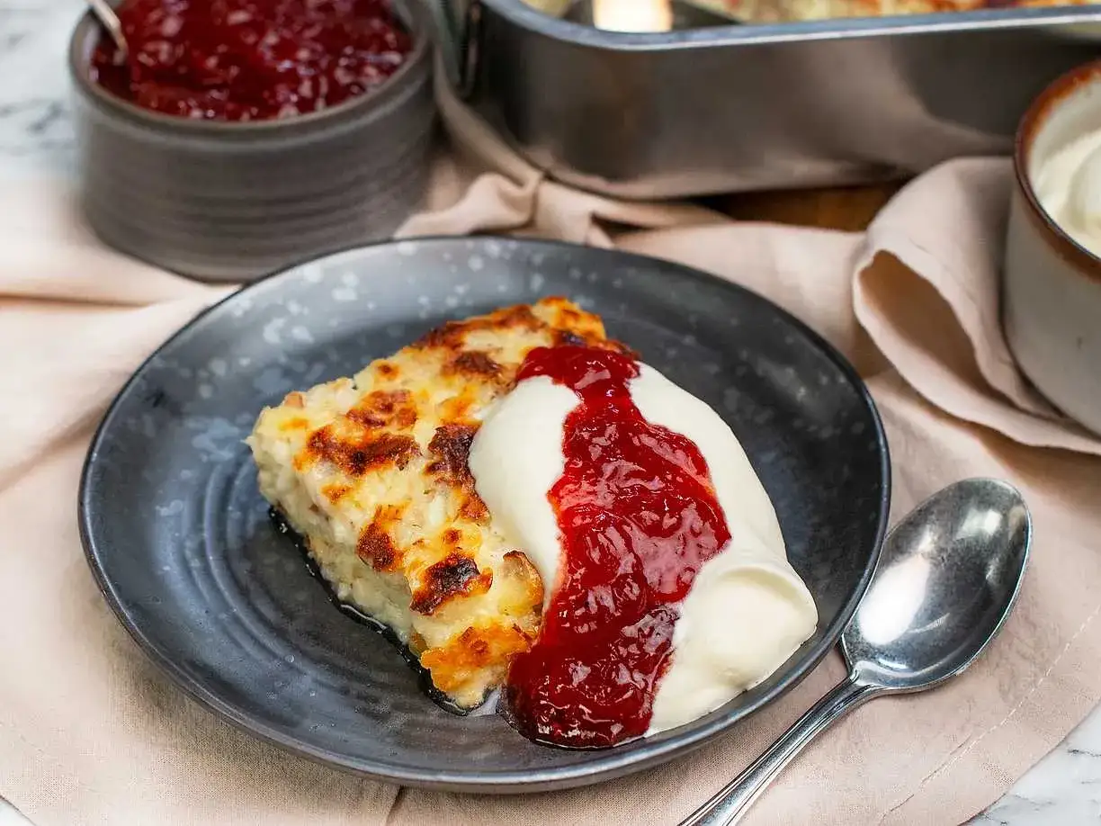 En bit gyllene ostkaka med vispad grädde och rårörda lingon. Ett perfekt ostkaka recept för fika.