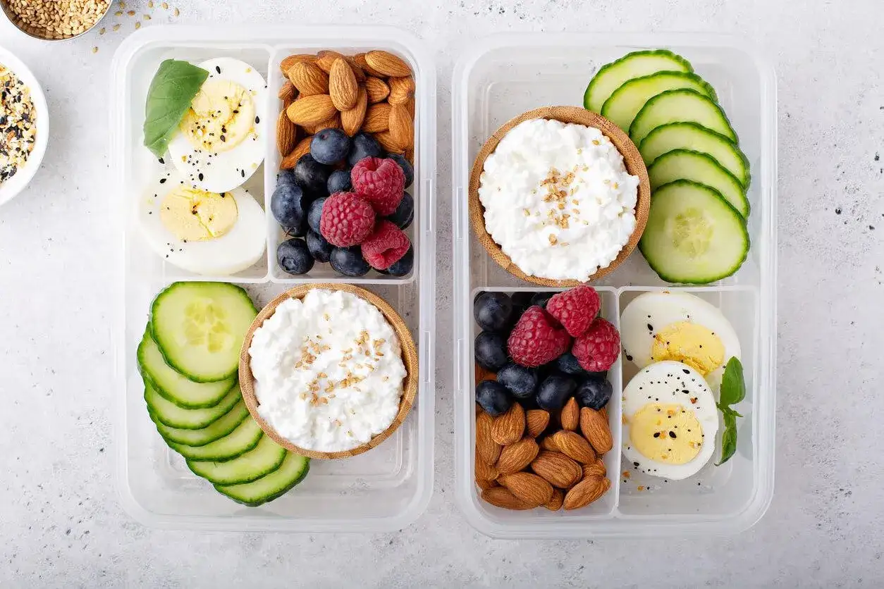 Tv&aring; matl&aring;dor fyllda med lchf snacks: &auml;gg, n&ouml;tter, b&auml;r, gurka och keso. Perfekt f&ouml;r en h&auml;lsosam lunch.
