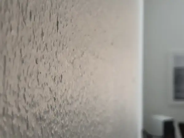 Närbild på en vägg där man kan se hur det ser ut att måla på strukturtapet. Texturen är tydlig.