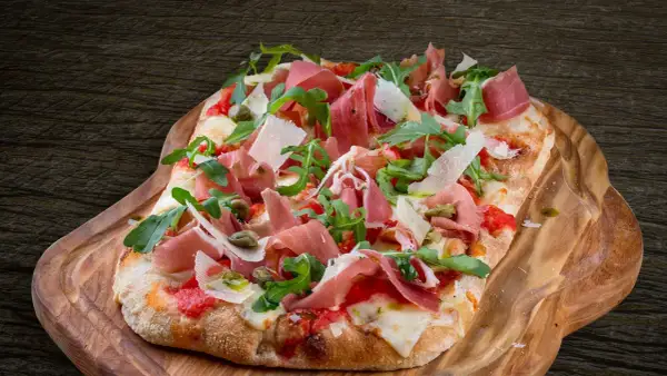 En avsmaklig pinsa med prosciutto, ruccola och parmesan. Ett perfekt pinsa recept för en härlig måltid.