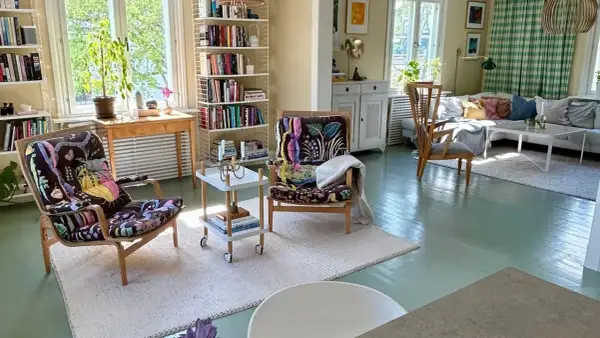 Ljust och luftigt vardagsrum med två färgstarka fåtöljer, bokhyllor och en soffgrupp. En känsla av harmoni och lugn som passar bra för feng shui vardagsrum.